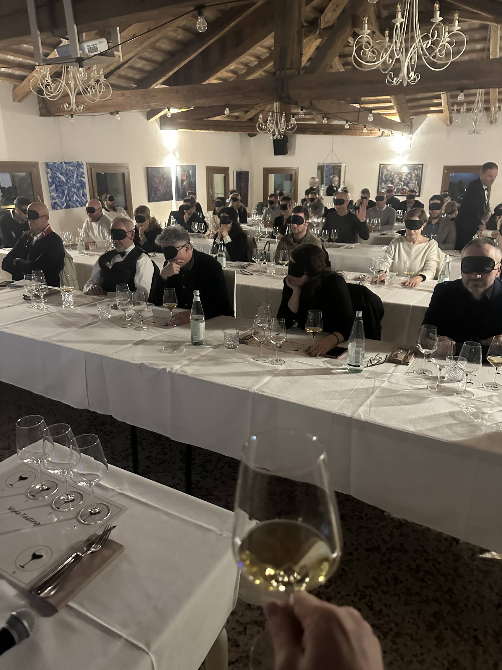 Sala con i partecipanti bendati durante una degustazione al buio